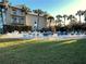 Lush green grass and poolside seating surround the pool area and the condo building at 3400 Gulf Blvd # 304, Belleair Beach, FL 33786