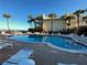 Poolside view offering ocean glimpses and a tranquil setting for outdoor enjoyment and relaxation at 3400 Gulf Blvd # 304, Belleair Beach, FL 33786