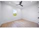 Minimalist bedroom design with wood flooring, a modern ceiling fan, and a window with a view at 3601 W Platt St, Tampa, FL 33609