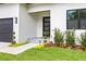 Inviting front entrance displaying a modern black door, elegant landscaping, and a welcoming walkway to the home at 3601 W Platt St, Tampa, FL 33609