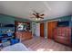 Bedroom with wood floors, ceiling fan, closet, dresser and TV at 38055 Avion Dr, Zephyrhills, FL 33542