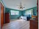 This bedroom features natural light, wood floors, a ceiling fan and neutral paint at 38055 Avion Dr, Zephyrhills, FL 33542