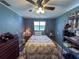 This bedroom features a ceiling fan, wood floors, and neutral paint at 38055 Avion Dr, Zephyrhills, FL 33542