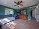 This bedroom features natural light, wood floors, and ceiling fan at 38055 Avion Dr, Zephyrhills, FL 33542