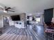 Open living room with blue-toned floors connecting to the kitchen and dining areas at 38055 Avion Dr, Zephyrhills, FL 33542