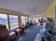 Airy sunroom featuring a wall of windows offering picturesque views and plenty of space for various activities and storage at 38055 Avion Dr, Zephyrhills, FL 33542