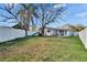 Large back yard with white fence, mature tree, slide, and patio at 415 Maplewood Cir, Oldsmar, FL 34677