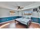 Bright bedroom with wood floors and large windows, offering views of the backyard at 415 Maplewood Cir, Oldsmar, FL 34677