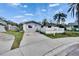 Charming single story home with a well manicured lawn, concrete driveway, and white picket fence at 415 Maplewood Cir, Oldsmar, FL 34677