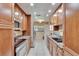 Modern kitchen features updated stainless steel appliances, granite countertops, and ample cabinet space at 415 Maplewood Cir, Oldsmar, FL 34677