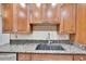 Close-up of kitchen featuring granite countertops, stainless sink, and ample cabinet space at 415 Maplewood Cir, Oldsmar, FL 34677