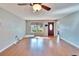 Bright living room with hardwood floors, fan, and a view to the front yard at 415 Maplewood Cir, Oldsmar, FL 34677