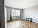 Bright bedroom featuring wood-look flooring and a window with white shutters and blue curtains at 4570 Overlook Ne Dr # 282, St Petersburg, FL 33703