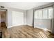 Bright bedroom featuring wood-look floors, neutral paint, and a closet with sliding doors at 4570 Overlook Ne Dr # 282, St Petersburg, FL 33703
