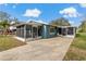 Features a concrete patio, an enclosed porch, and a well-maintained lawn in backyard at 4638 Heavens Way, New Port Richey, FL 34652