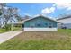 Well-maintained blue home with white trim and a spacious front yard on a sunny day at 4638 Heavens Way, New Port Richey, FL 34652