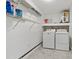 A laundry room with washer, dryer, shelves, and water heater at 4638 Heavens Way, New Port Richey, FL 34652