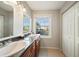 Bathroom with double sinks, granite countertops, and a large window at 4842 Coquina Key Se Dr # B, St Petersburg, FL 33705