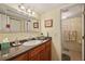 Bathroom featuring a large mirror, granite countertop, wood cabinets, and access to the shower at 4842 Coquina Key Se Dr # B, St Petersburg, FL 33705