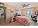Bedroom featuring floral bedspread, ceiling fan and access to outdoor patio at 4842 Coquina Key Se Dr # B, St Petersburg, FL 33705