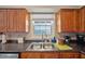 Kitchen featuring wood cabinets, granite countertops, stainless steel sink, and a window at 4842 Coquina Key Se Dr # B, St Petersburg, FL 33705