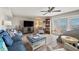 Comfortable living room with blue sofa, modern ceiling fan, and view of the outdoors at 4842 Coquina Key Se Dr # B, St Petersburg, FL 33705
