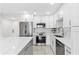 Well-lit kitchen featuring stainless steel appliances, a kitchen island and modern white cabinetry at 4900 Brittany S Dr # 408, St Petersburg, FL 33715