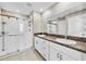 Sleek bathroom with double sinks, granite countertops, a glass-enclosed shower, and modern fixtures for a spa-like experience at 4943 Wild Senna Blvd, Tampa, FL 33619