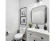 Modern half bathroom with a black framed mirror, sleek vanity and decorative wall art at 5323 Sandy Shell Dr, Apollo Beach, FL 33572