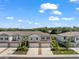 Community view of townhomes with 2 car garages, landscaping, and ample parking at 5994 Shiner St, Land O Lakes, FL 34638