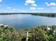 Panoramic aerial of a lake, showcasing the dock, lush trees, and lakefront homes at 5994 Shiner St, Land O Lakes, FL 34638