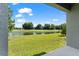 Spacious backyard with lush green lawn and a serene lake view under a clear sky at 5994 Shiner St, Land O Lakes, FL 34638