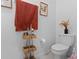 Cozy bathroom featuring elegant decor, a toilet, and a stylish towel rack with autumn-themed accents at 5994 Shiner St, Land O Lakes, FL 34638