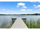 A dock extends into a peaceful lake, perfect for fishing and scenic relaxation at 5994 Shiner St, Land O Lakes, FL 34638
