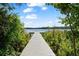 Inviting dock on the lake, surrounded by lush greenery and leading to serene waters at 5994 Shiner St, Land O Lakes, FL 34638