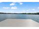 A close-up view of a dock and its platform on a calm lake under a blue, partly cloudy sky at 5994 Shiner St, Land O Lakes, FL 34638