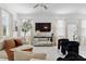 Bright living room with neutral tones, stylish decor, plush seating, large TV, and ample natural light at 5994 Shiner St, Land O Lakes, FL 34638
