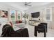 Open concept living room featuring a large sofa, modern decor, and ample natural light at 5994 Shiner St, Land O Lakes, FL 34638