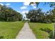 Scenic pathway leading through a lush, tree-filled landscape under a sunny sky at 5994 Shiner St, Land O Lakes, FL 34638
