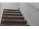 Carpeted staircase with neutral tones, providing access to the upper level of the home at 5994 Shiner St, Land O Lakes, FL 34638