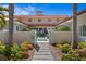 Elegant two-story home with a gated entrance, beautiful landscaping, and a charming walkway at 611 Brightwaters Ne Blvd, St Petersburg, FL 33704