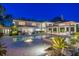 Beautiful Mediterranean-style home featuring an outdoor living space, pool, and fire feature at night at 611 Brightwaters Ne Blvd, St Petersburg, FL 33704