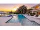 Gorgeous pool with a sun shelf, hot tub, and beautiful landscaping at sunset at 611 Brightwaters Ne Blvd, St Petersburg, FL 33704