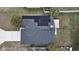 Aerial view of home featuring solar panels, gray roof, paved driveway, and well-manicured surroundings at 6512 N 24Th St, Tampa, FL 33610