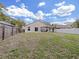 Expansive backyard featuring a covered patio, sliding glass doors, a white fence, and lush green grass at 6512 N 24Th St, Tampa, FL 33610