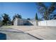 View of the home's gray exterior, with a white fence and concrete patio area at 8901 N 20Th St, Tampa, FL 33604