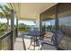 Outdoor balcony with views of the water featuring a table, chairs, and tropical landscaping at 9525 Blind Pass Rd # 301, St Pete Beach, FL 33706
