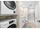 Well-lit bathroom featuring a washer, dryer, walk-in shower, white vanity, and wood-look flooring at 9525 Blind Pass Rd # 301, St Pete Beach, FL 33706