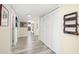 Hallway with wood-look flooring, closet, decor, and leads to the living area and kitchen at 9525 Blind Pass Rd # 301, St Pete Beach, FL 33706