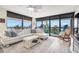 Sun-drenched living room with large windows showcasing scenic views and comfortable seating at 9525 Blind Pass Rd # 301, St Pete Beach, FL 33706